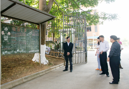 （圖一）檢查組一行正在檢查宿舍區(qū)宣傳欄情況